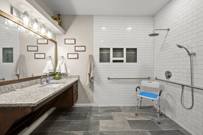 Accessible bathroom with grab bars and shower chair.