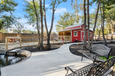 Pathway leading to a red barn in a garden