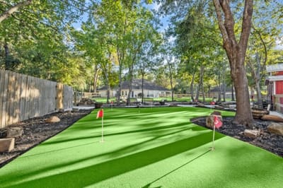 Outdoor putting green with artificial turf and trees