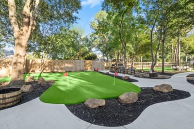 Outdoor putting green surrounded by trees