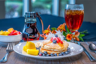 Plated pancakes with fruit on a dining table