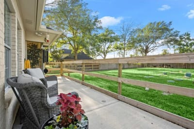 Outdoor seating area with greenery and fence.