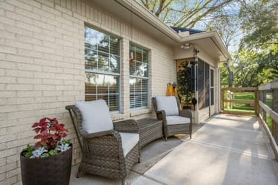 Outdoor seating area with chairs and plants.