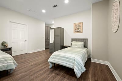 Simple, well-lit shared bedroom with twin beds.