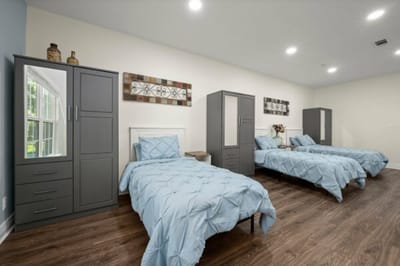Shared bedroom with two beds and cabinetry.