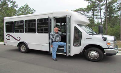 Senior resident stepping into facility vehicle