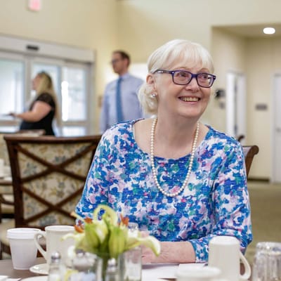 Senior woman smiling at a dining table