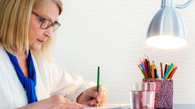 Resident engaging in creative activity at a table.