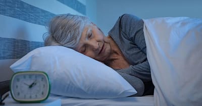 Senior woman sleeping peacefully in a bedroom.