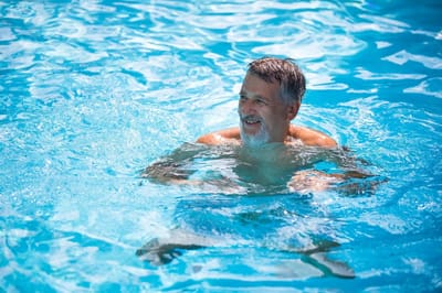 Senior man enjoying swimming in a pool