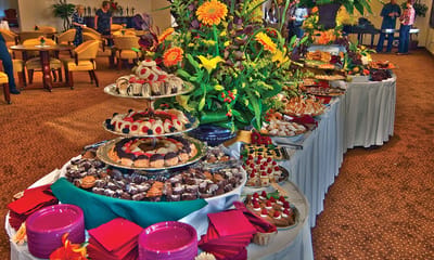 A beautifully arranged buffet with desserts and flowers.