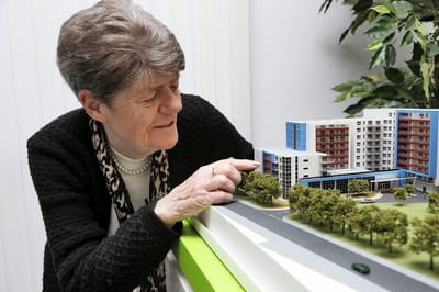Senior resident interacting with a model of the facility