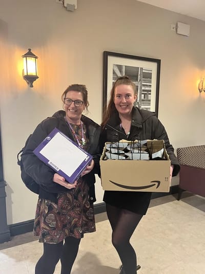 Two staff members holding packages in the facility