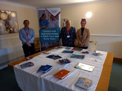Staff members at a table promoting care opportunities.