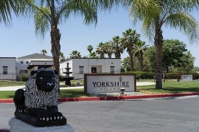 Entrance of Yorkshire Village with palm trees and a lion statue