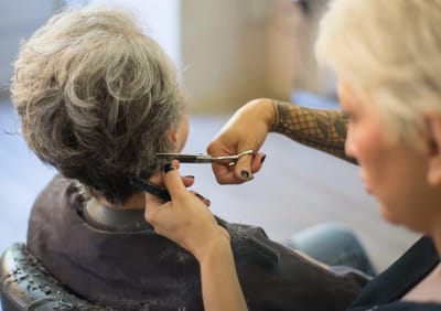 Stylist cutting hair for a resident.