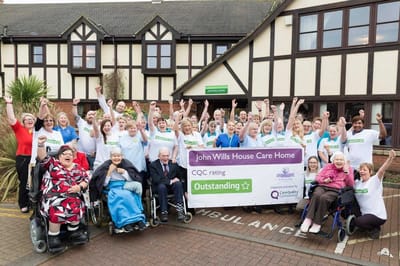 Cheerful staff and residents celebrating outside.
