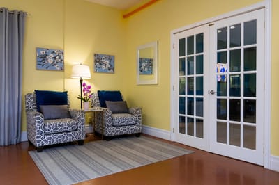 Cozy sitting area with armchairs and decorative paintings.