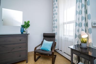 Cozy resident room with a chair and window.