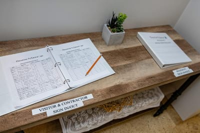 Sign-in table with registration books and a plant.