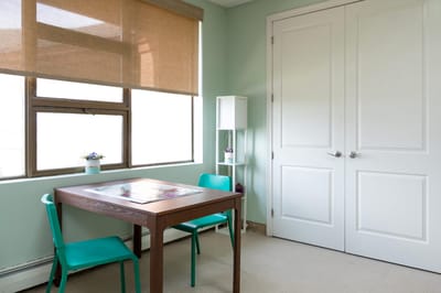 Brightly lit interior room with a table and chairs.