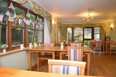 Interior dining area with wooden tables and floral decor.