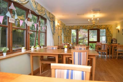 Dining area with wooden tables and windows.
