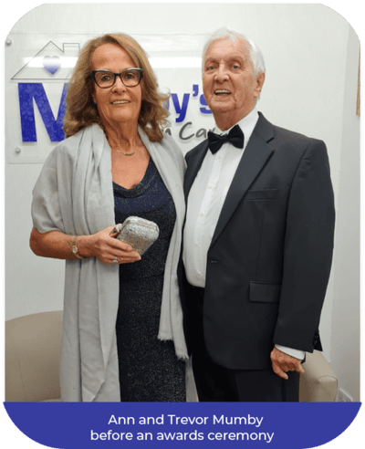 Couple dressed for an awards ceremony in a common area.