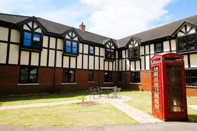 Red telephone booth in a landscaped courtyard