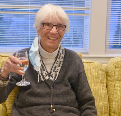 Senior resident smiling with a drink in hand