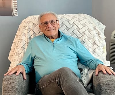 Senior man relaxing in a cozy chair at the facility.