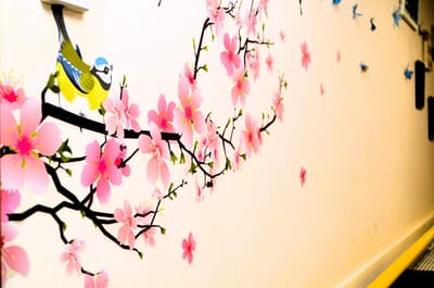 Colorful wall art with flowers and a bird.