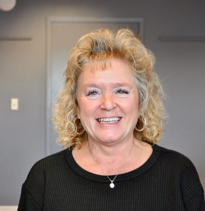 Smiling staff member in an interior setting.