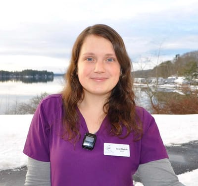 Staff member posing outdoors with a lake view.
