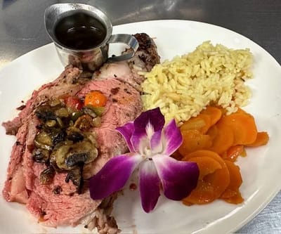 Plated meal featuring roast beef and vegetables.