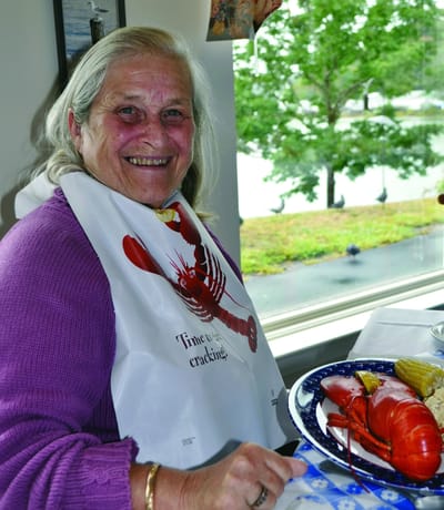 Senior woman enjoying a meal with lobster.