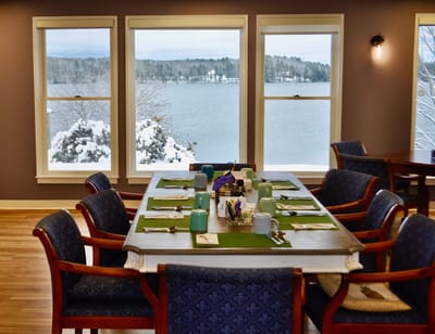 Dining room with lake view and snowy landscape