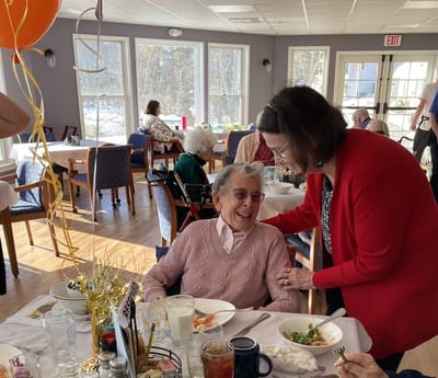 Residents enjoying a meal and celebration indoors.