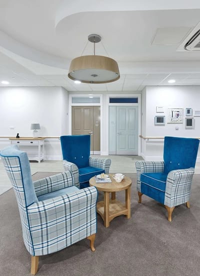 Cozy seating area with blue chairs and a small table.