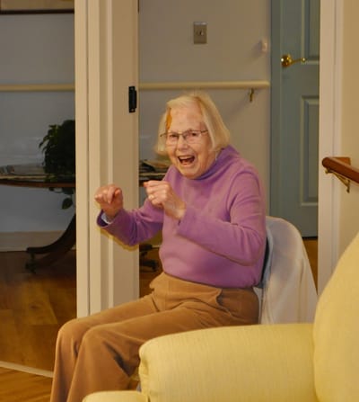 Elderly woman joyfully seated in a common area