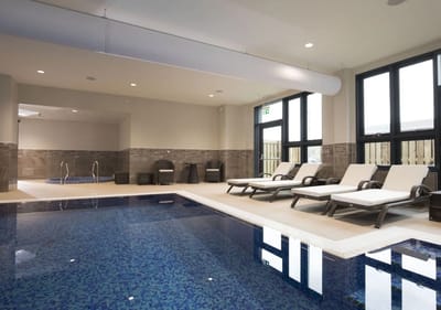 Indoor pool area with lounge chairs