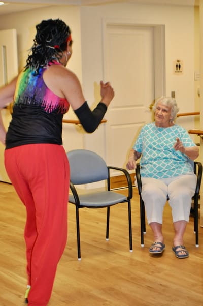 Senior resident engaging in an activity with staff
