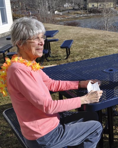 Senior woman enjoying the outdoors at a picnic table.