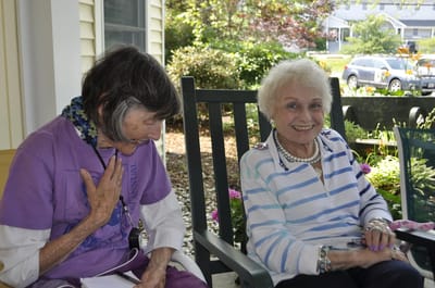 Two seniors chatting on a porch