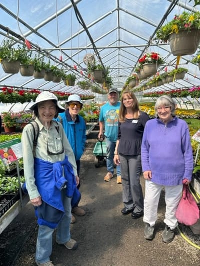 Residents and staff in a greenhouse activity.