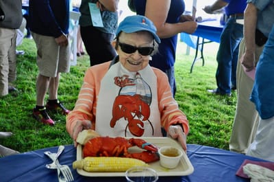 Resident enjoying a lobster meal at an outdoor event