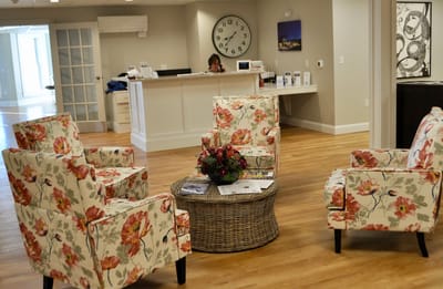 Welcoming common area with floral chairs and reception.