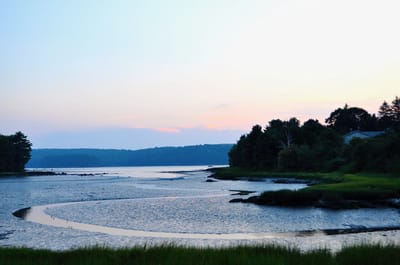 Scenic view of a tranquil shoreline at sunset.