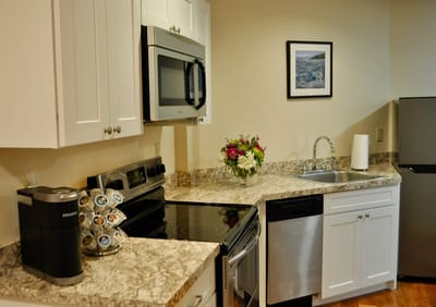 Bright kitchen area with modern appliances and flowers.