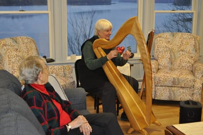 Resident enjoying a harp performance inside the facility.